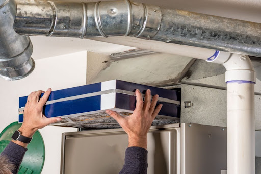 Technician replacing a furnace filter