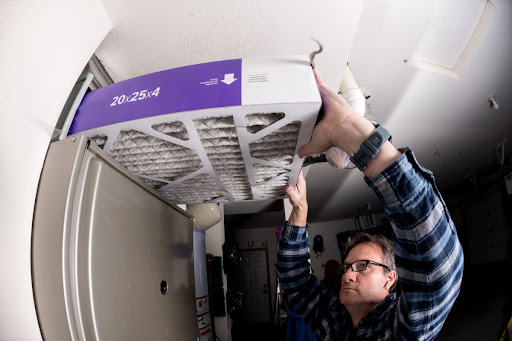 Man changing an air filter in a residential furnace